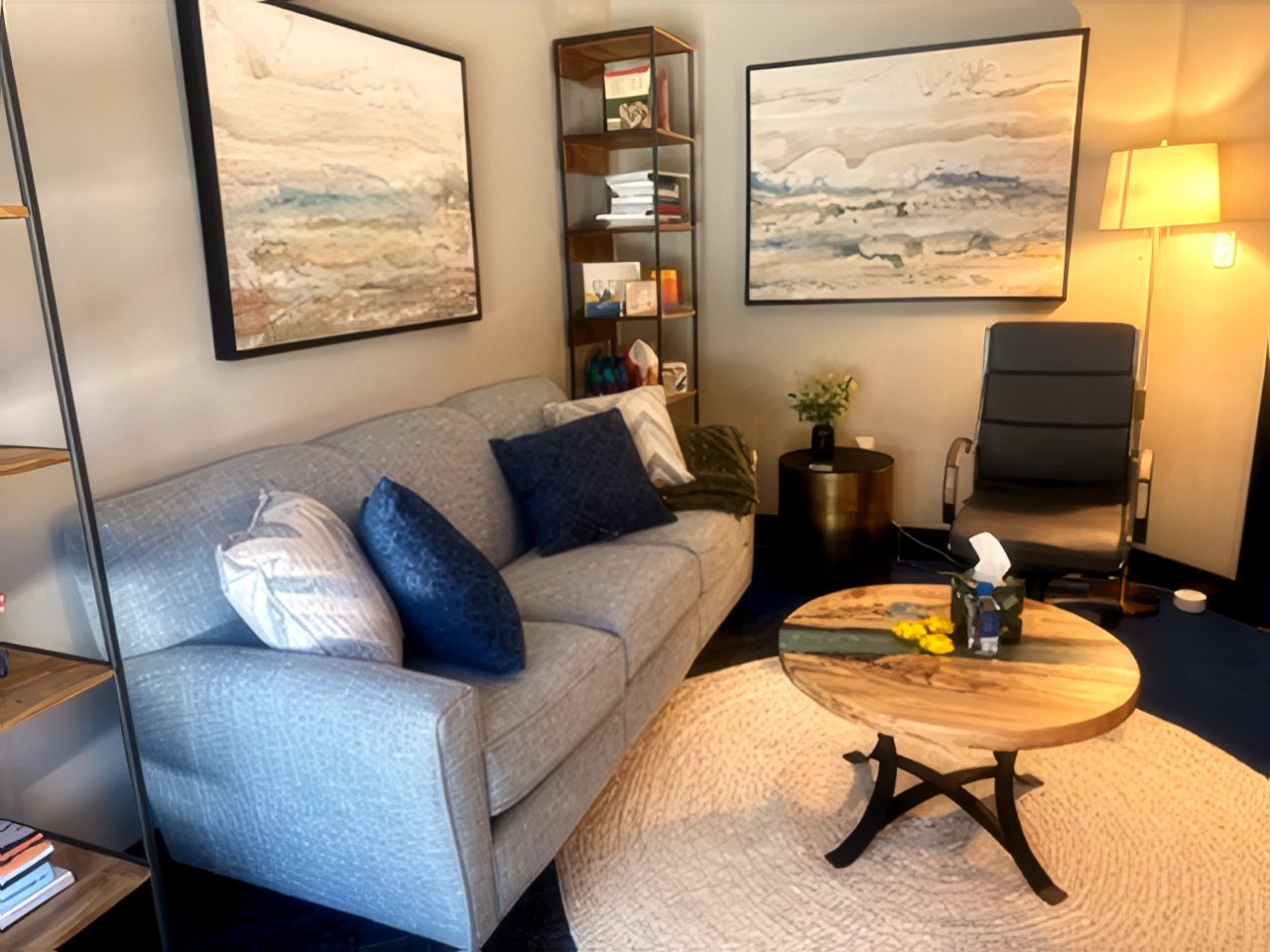 Seating corner of the office with pillows, plants, and calming artwork